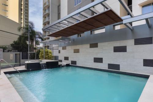 a swimming pool in front of a building at SK2 - CHARMING Skyline CBD w River Views 3 BR Private Apartment in Brisbane