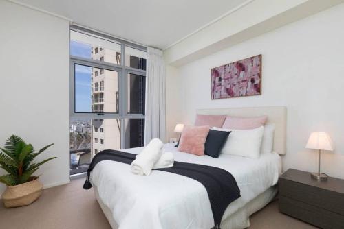 a bedroom with a large bed and a large window at SK2 - CHARMING Skyline CBD w River Views 3 BR Private Apartment in Brisbane