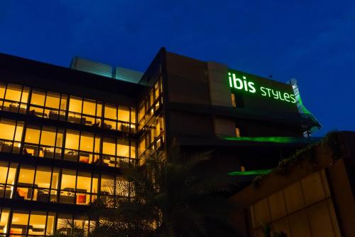 a building with a bus stripes sign at night at Ibis Styles Singapore On Macpherson in Singapore