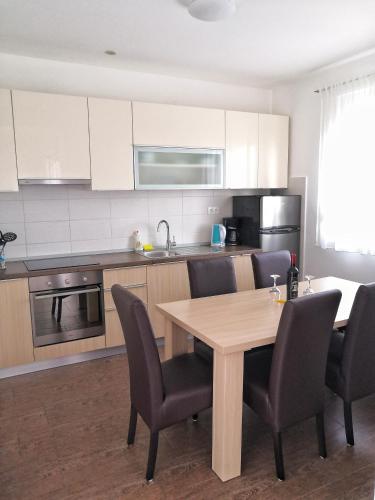 a kitchen with a wooden table and chairs in a kitchen at Apartments Nostro in Omiš