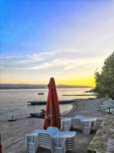 a group of umbrellas sitting on a beach near the water at Apartments Nostro in Omiš