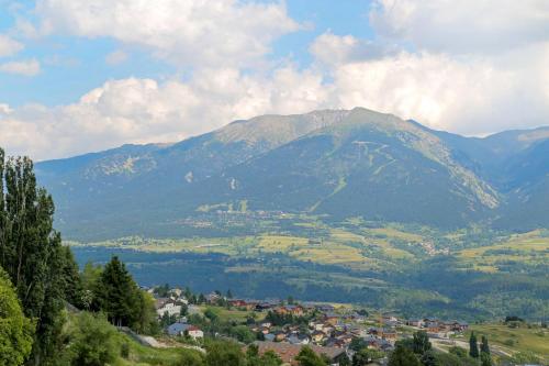 a mountain in the distance with a town in the foreground at Résidence Pierre & Vacances Le Pédrou in Font-Romeu