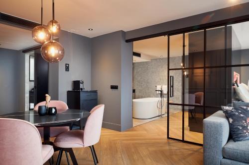 a dining room and living room with a table and chairs at Van der Valk Hotel Antwerpen in Antwerp
