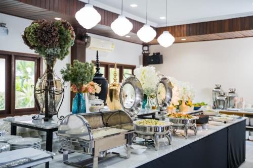 a buffet line with dishes and flowers and lights at Kong Garden View Resort Chiang Rai in Chiang Rai