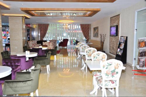 a restaurant with white chairs and tables and tablesearcher at Hanem Hotel in Malatya