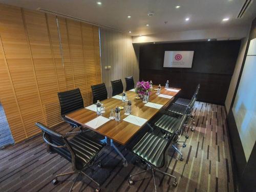 a conference room with a long wooden table and chairs at Amaranth Suvarnabhumi Hotel - Free Suvarnabhumi Airport Shuttle in Lat Krabang