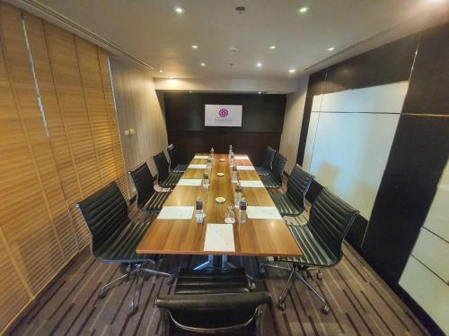 a conference room with a long wooden table and chairs at Amaranth Suvarnabhumi Hotel - Free Suvarnabhumi Airport Shuttle in Lat Krabang