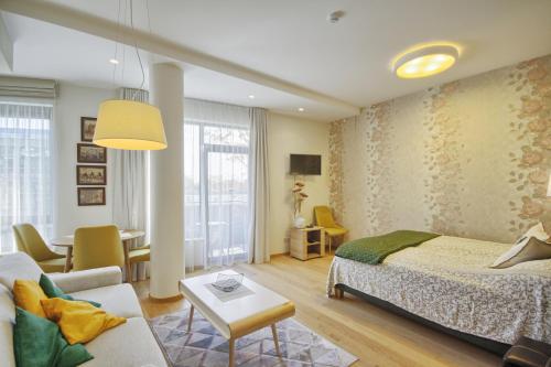 een slaapkamer met een bed en een woonkamer bij Valensia Apartment in Druskininkai