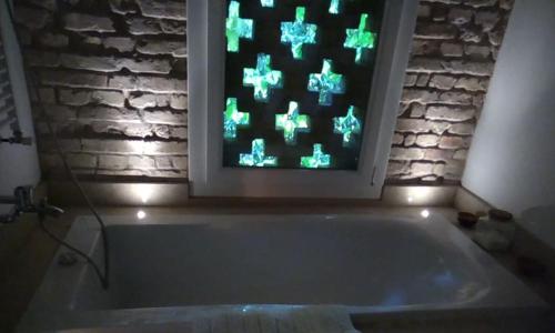 un bagno con vasca e finestra con luci verdi di Ca' del Tajo a Teglio Veneto
