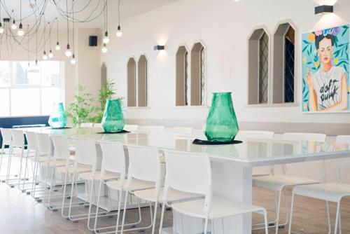 a long table with white chairs and blue vases at Bridge Backpackers in Nelson
