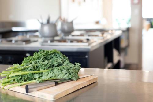 a pile of greens on a cutting board on a counter at Bridge Backpackers in Nelson