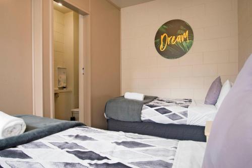 a bedroom with two beds and a sign on the wall at Bridge Backpackers in Nelson