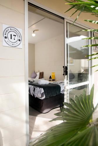 a bedroom with a bed and a sliding glass door at Bridge Backpackers in Nelson