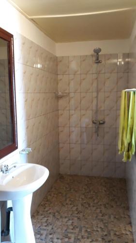 a bathroom with a sink and a shower at Hotel Robinson Plage in Lomé