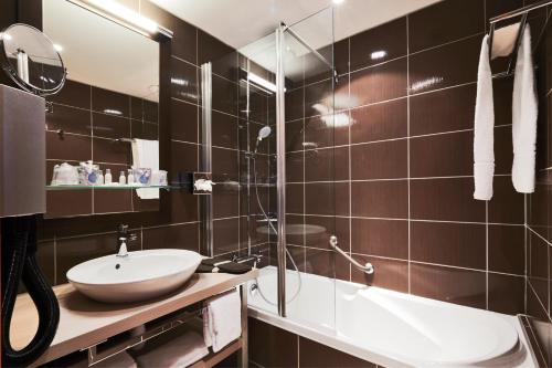 a bathroom with a shower and a sink and a tub at Hotel Dijon Nord Valmy - Futur Ibis Styles Mai 2024 in Dijon