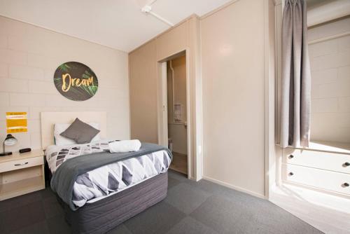 a bedroom with a bed and a dresser in it at Bridge Backpackers in Nelson