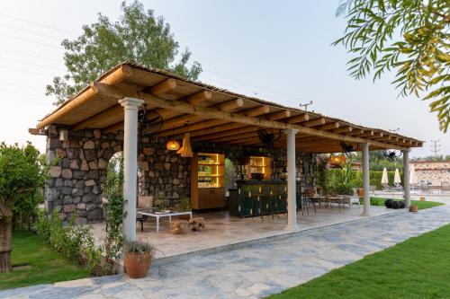 a wooden pavilion with a stone wall at Zigo's Hotel in Mugla