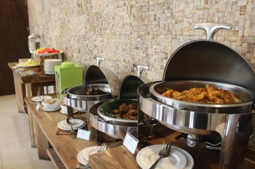 una línea buffet con comida en sartenes metálicas en Greenotel Cilegon, en Cilegon