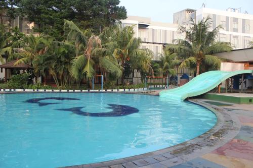 a swimming pool with a slide in a resort at Greenotel Cilegon in Cilegon