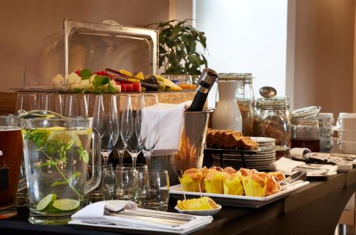 a table with plates of food and a bottle of wine at Hotel Bellotto in Warsaw