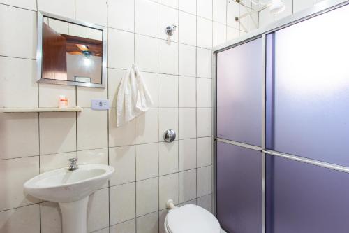 a bathroom with a toilet and a sink and a shower at Hotel America in Jacareí
