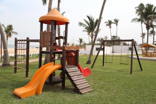 a playground with a slide in a park with palm trees at Sunbeach Hotel & Resort in Bakau
