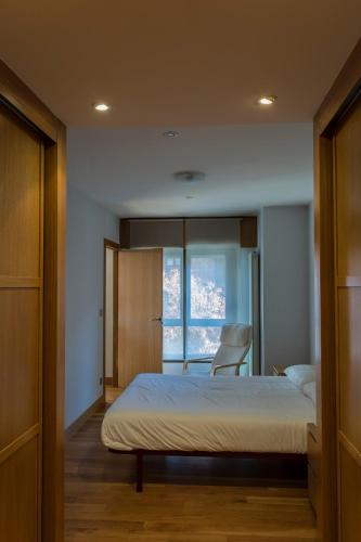 a bedroom with a bed with a chair and a window at Bidasoa by Basquelidays in Irún