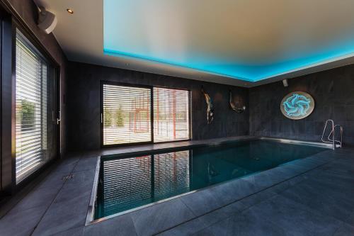 a large swimming pool in a house at Barok Hotel and Apartments in Bratislava