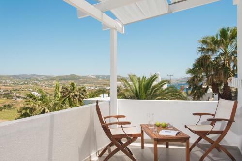 a balcony with chairs and a table with fruit on it at Alexandros Village in Adamas