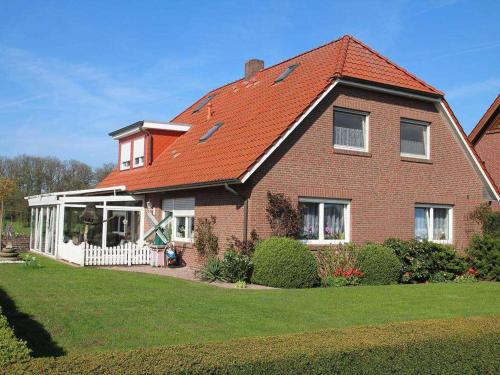 una casa de ladrillo marrón con techo rojo en Ferienwohnung am Kaiserwald, 15191, en Leer