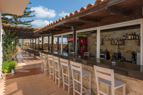 a bar with a row of chairs at a restaurant at Hermes Hotel in Kissamos