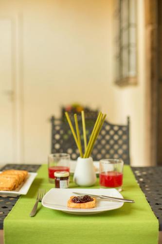 a table with a plate of food on a green table cloth at LUCUS Exclusive Bed and Breakfast in Lucca