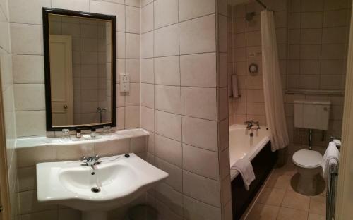 a bathroom with a sink and a tub and a toilet at Imperial Hotel Blackpool in Blackpool