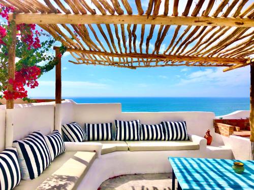 - un canapé blanc assis sous une pergola donnant sur l'océan dans l'établissement Villa Jardin De l'Ocean, à Aourir