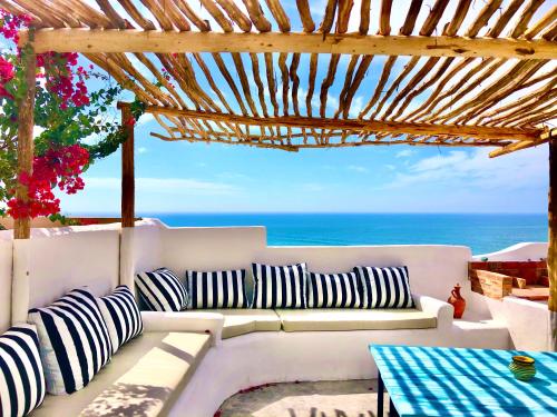 a white couch sitting under a pergola overlooking the ocean at Villa Jardin De l'Ocean in Aourir