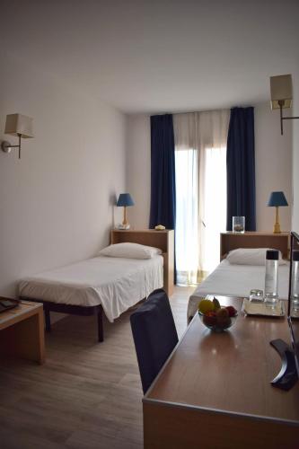 a hotel room with two beds and a table at Hotel Giardino d'Europa in Rome