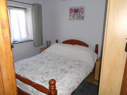 ein kleines Schlafzimmer mit einem Bett in einem Zimmer mit einem Fenster in der Unterkunft Auld Ffynnon in Brecon