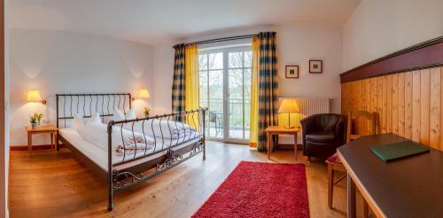 um quarto com uma cama e uma secretária e uma mesa sidx sidx em Brauereigasthof-Jakob em Nittenau