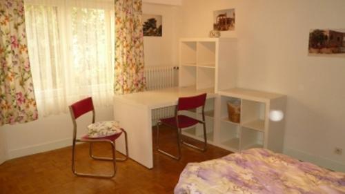 トゥールにあるAppartement Centre Ville Toursのベッドルーム1室(デスク、椅子2脚、ベッド1台付)