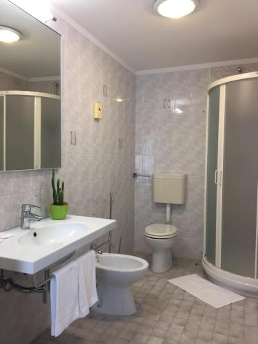 a bathroom with a sink and a toilet and a shower at Hotel Storione in Lido di Jesolo