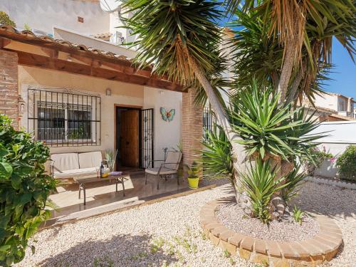 a patio with a white couch and palm trees at Belvilla by OYO Casa Crispin in Ciudad Quesada