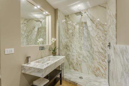 W łazience znajduje się marmurowy prysznic i umywalka. w obiekcie Sophisticated Home we Florencji