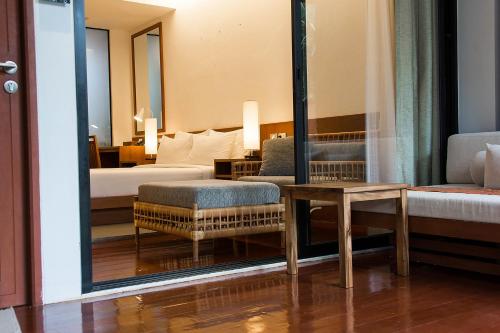 a hotel room with a bed and a table and a mirror at Tri-Shawa Resort in Klong Wan