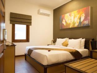 a bedroom with a bed and a painting on the wall at Samara Resort in Batu