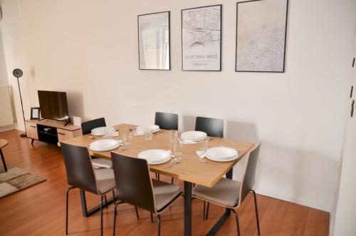 a dining room with a wooden table and chairs at Studio D&T in Slavonski Brod