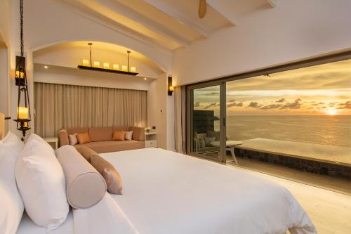a bedroom with a large bed and a view of the ocean at The Shore At Katathani - Adult Only - SHA Extra Plus in Kata Beach