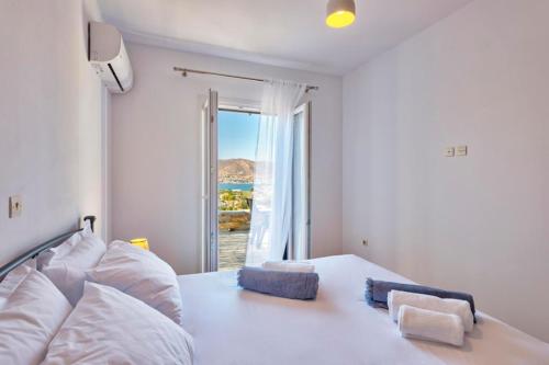 a bedroom with a bed with a view of the ocean at Oceania House with sea view in Ano Syros