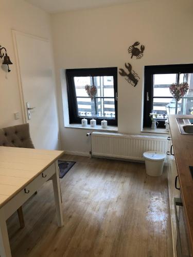 a kitchen with two windows and a wooden floor at Altstadt Quartier Hameln in Hameln