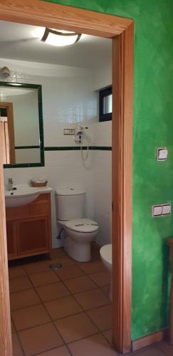 a bathroom with a toilet and a sink at Hotel Sara De Ur in La Cabrera