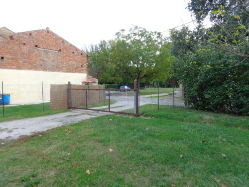 a fence in a yard next to a building at 34 Rue de la Coucouroune Gîte de la Coucouroune in Soual